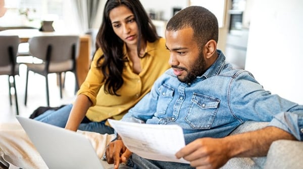 Man and lady on sofa looking at laptop