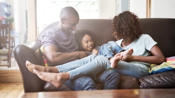 Cheerful family sitting on sofa at home