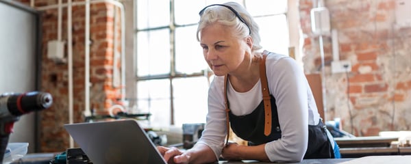 Mature woman using a laptop in a workshop