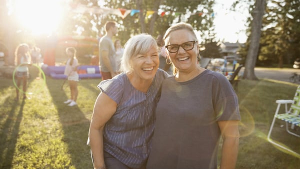 mother and grown up daughter smiling at a party