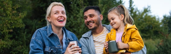 Family sitting together outside, embracing