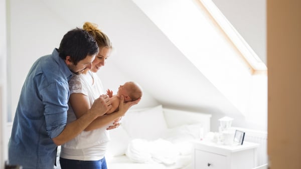 couple together holding their new baby