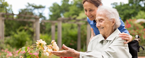 Senior woman sitting on a wheelchair with caregiver