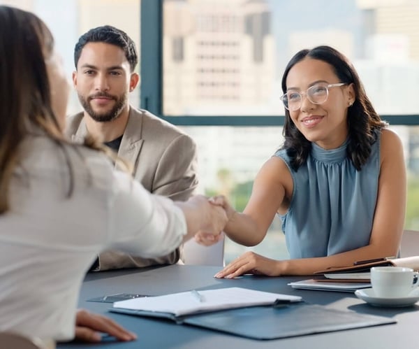 Two ladies shaking hands over a table