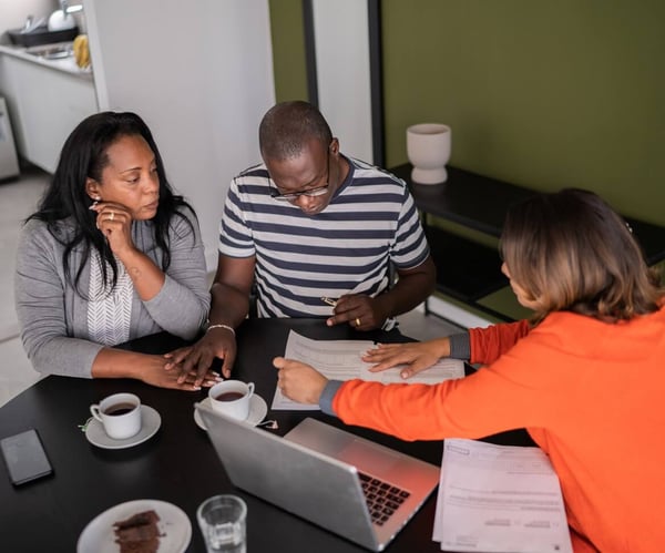 A birds eye view of a couple singing paperwork, on a table with another lady