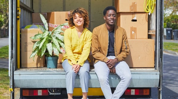 Couple sitting on the back of a removals van