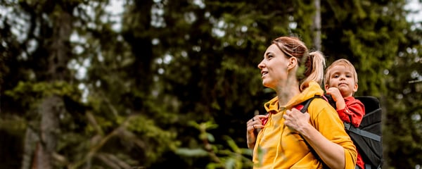 Woman hiking with child in a carrier on her back