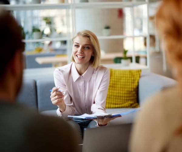 A woman sat at work, talking with colleagues