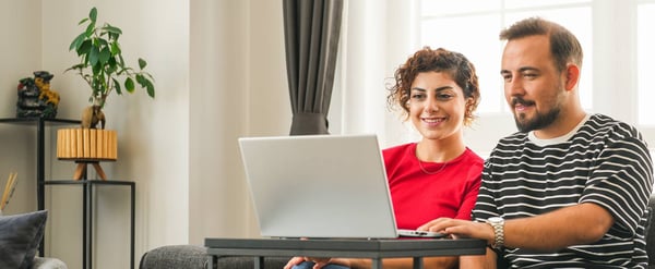 Couple on sofa looking at laptop
