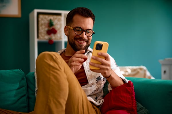Man looking at phone wearing glasses
