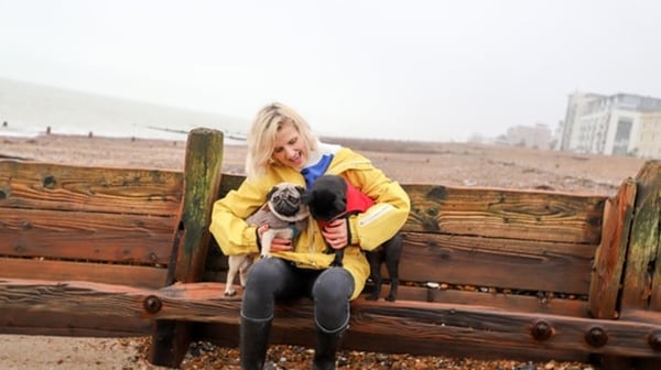 Senior woman with dogs on the beach