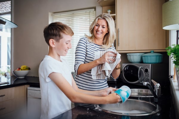 Mother and son doing the washing up together