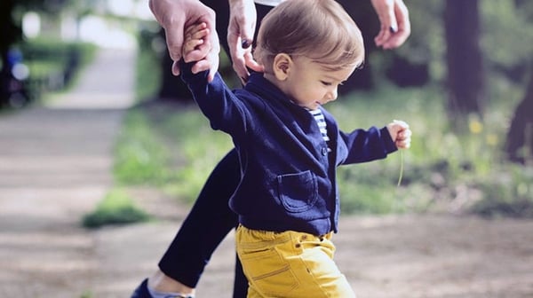 Toddler walking with grandparents