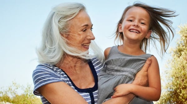 Mature woman holding her grandchild smiling