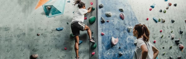 Women ascending a climbing wall