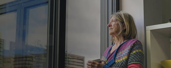 Older woman staring out of window