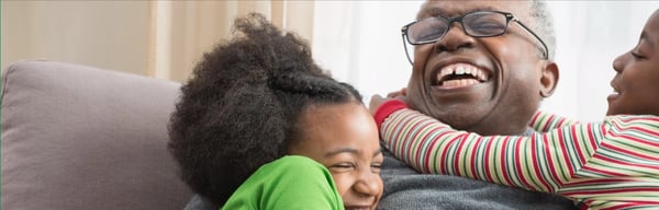 Older man hugging grandchildren