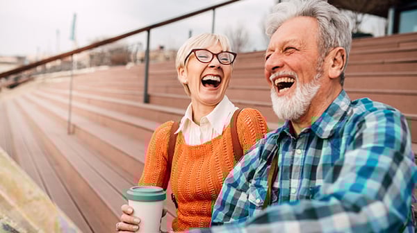Older man and woman laughing outside