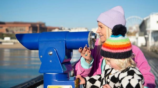 Lady with child looking through telescope