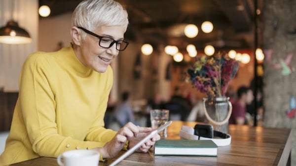 Woman in bright yellow jumper studying on an iPad