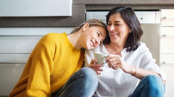 Two ladies sitting down smiling