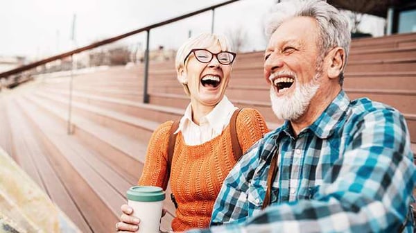 Older man and woman laughing outside