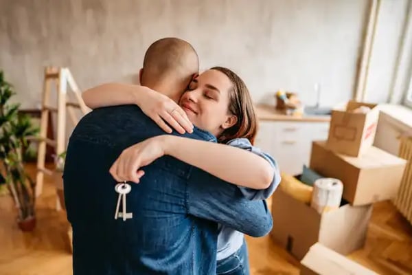 Young couple hold keys as they've bought first home