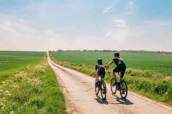 Shot of a mature father and daughter riding their road bikes on a country lane