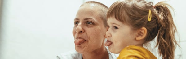 Woman with cancer having fun with young daughter