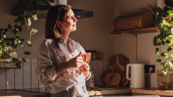 Lady drinking tea and looking out of window