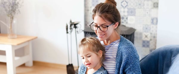 Woman with child sitting at laptop looking at private pensions