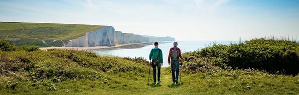 Two people on a country walk with cliffs and the sea