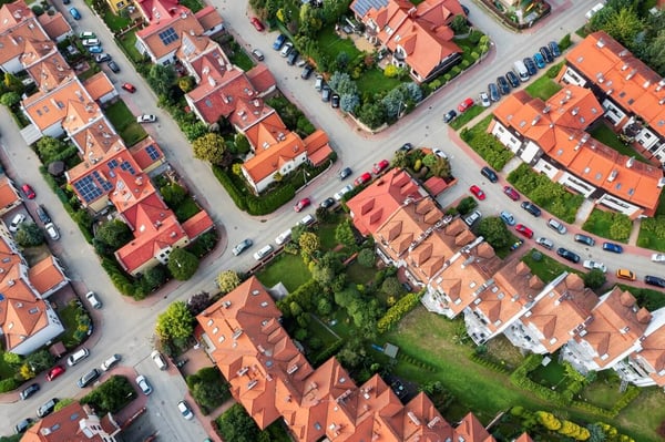 An aerial view of houses with red roofs in rows
