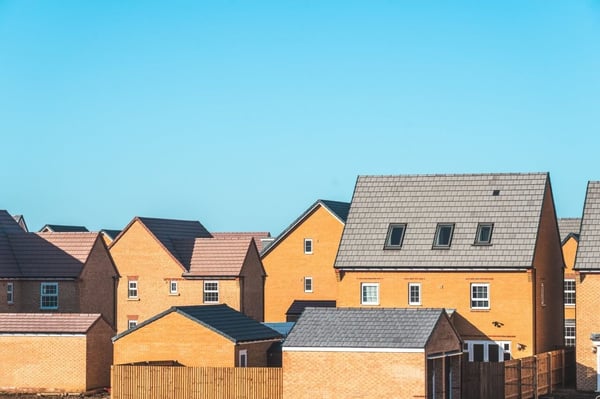 The tops of houses amongst a blue sky
