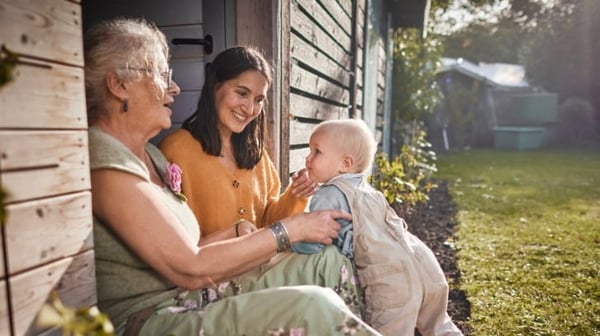 Grandmother, mother and baby smiling in the garden