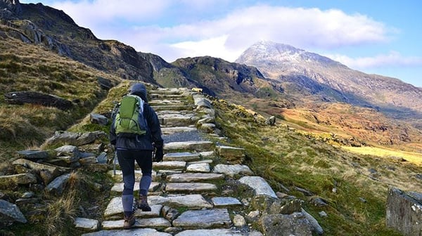 Hiker walking up a stone path