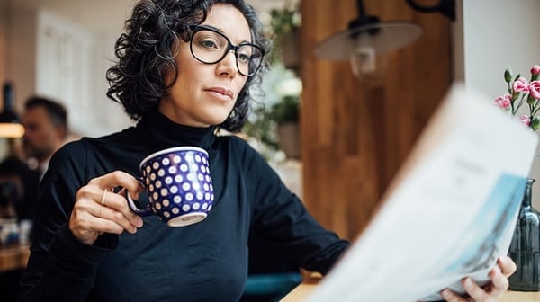 Woman holding a mug and reading a document