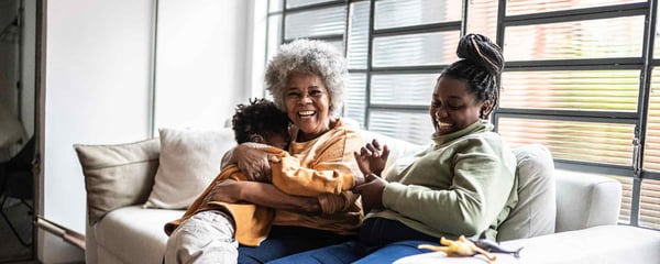 Family laughing on sofa