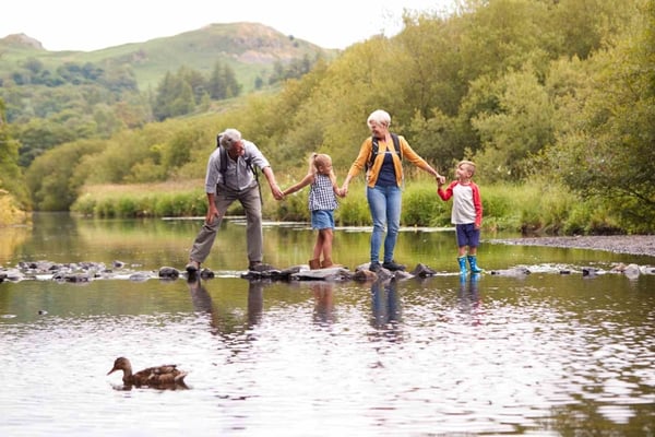 Family walking along stones in a river