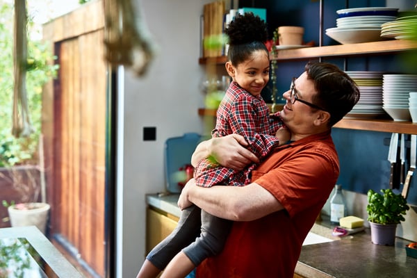 Dad picking up daughter and laughing