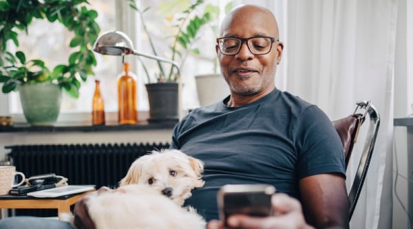 Retired senior male with dog in room at home