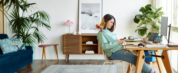Woman staring at mobile phone with cartoon squirrel on her shoulder