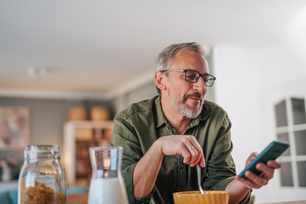 Man smiling while looking at his phone