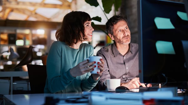 Woman and man at computer in office