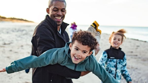 Man and family playing on a beach