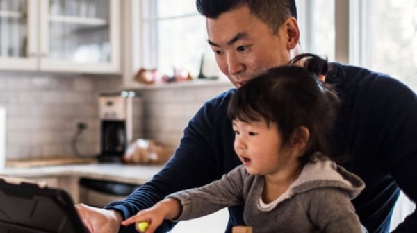 Man and child pointing at laptop screen