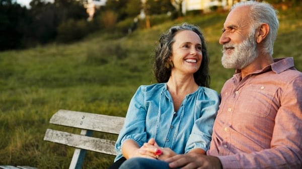 couple-sat-in-field-smiling-smaller image