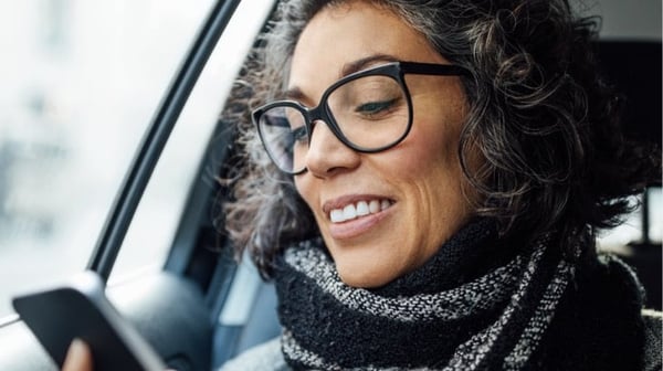 Woman car passenger looking at phone