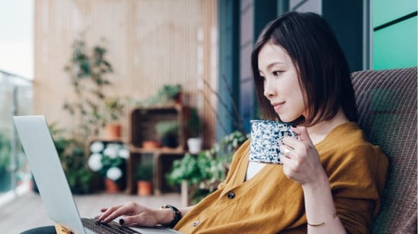 Woman relaxing with coffee and laptop