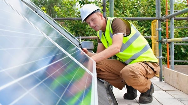 Worker installing solar panels